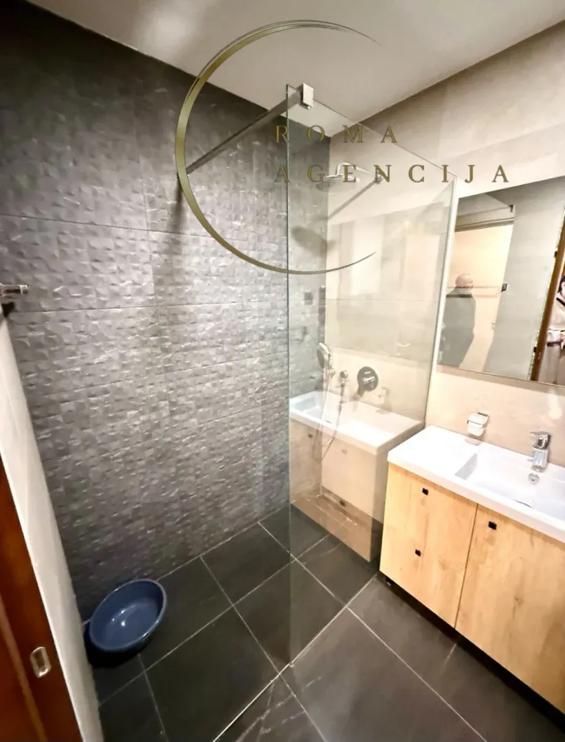 Modern bathroom with walk-in shower and vanity unit.