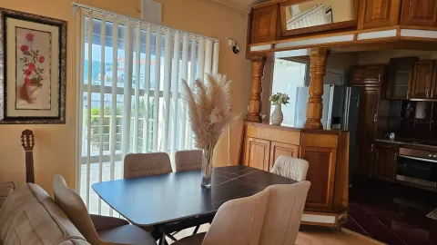 Dining area with a table, chairs, and a view of the terrace. - image 12