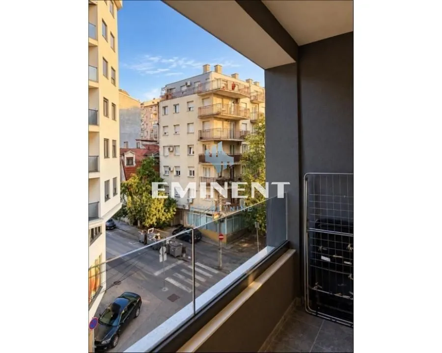 View from the balcony overlooking the city street and surrounding buildings.