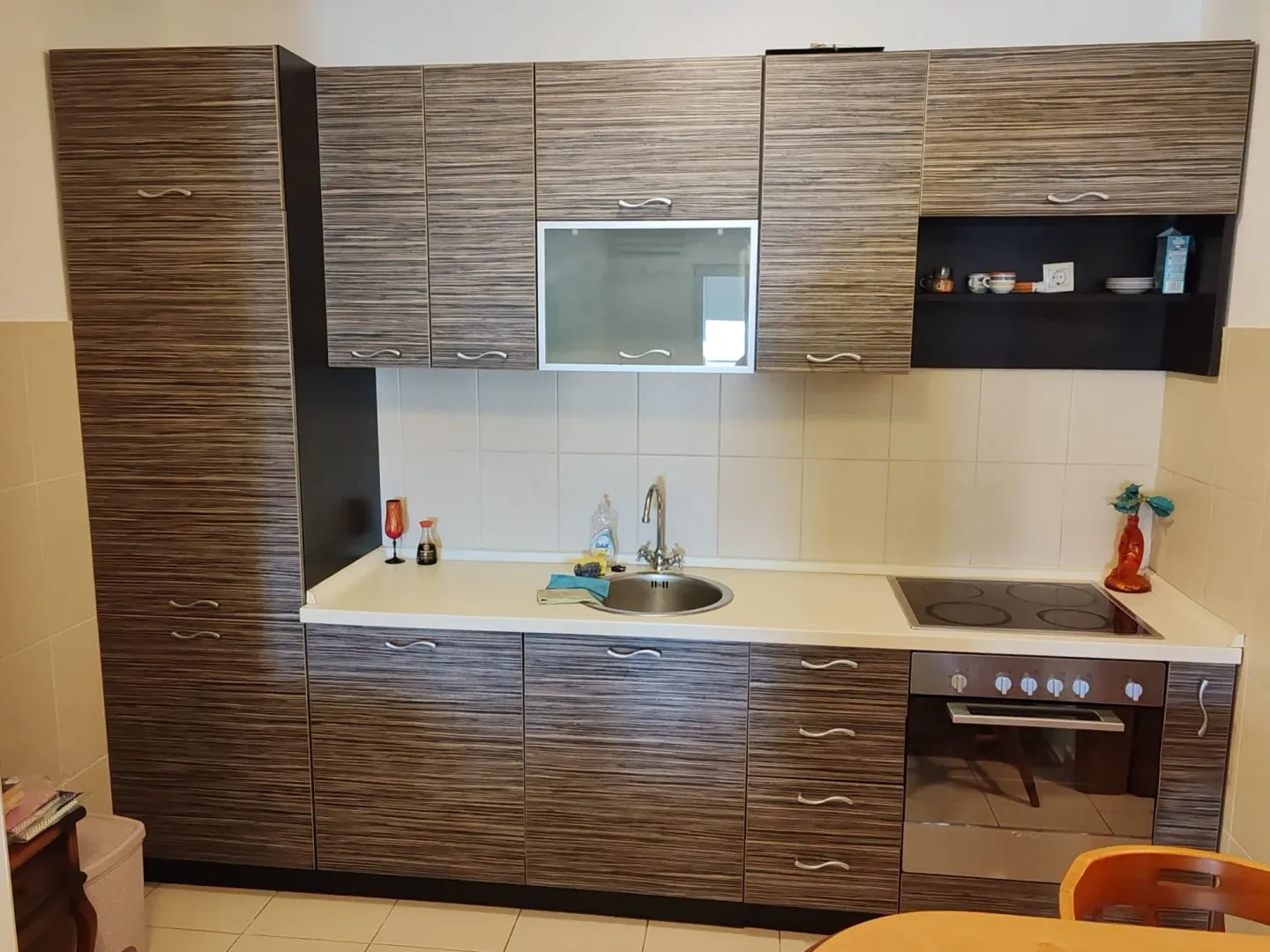 Modern kitchen with wood-grain cabinets and a built-in cooktop.