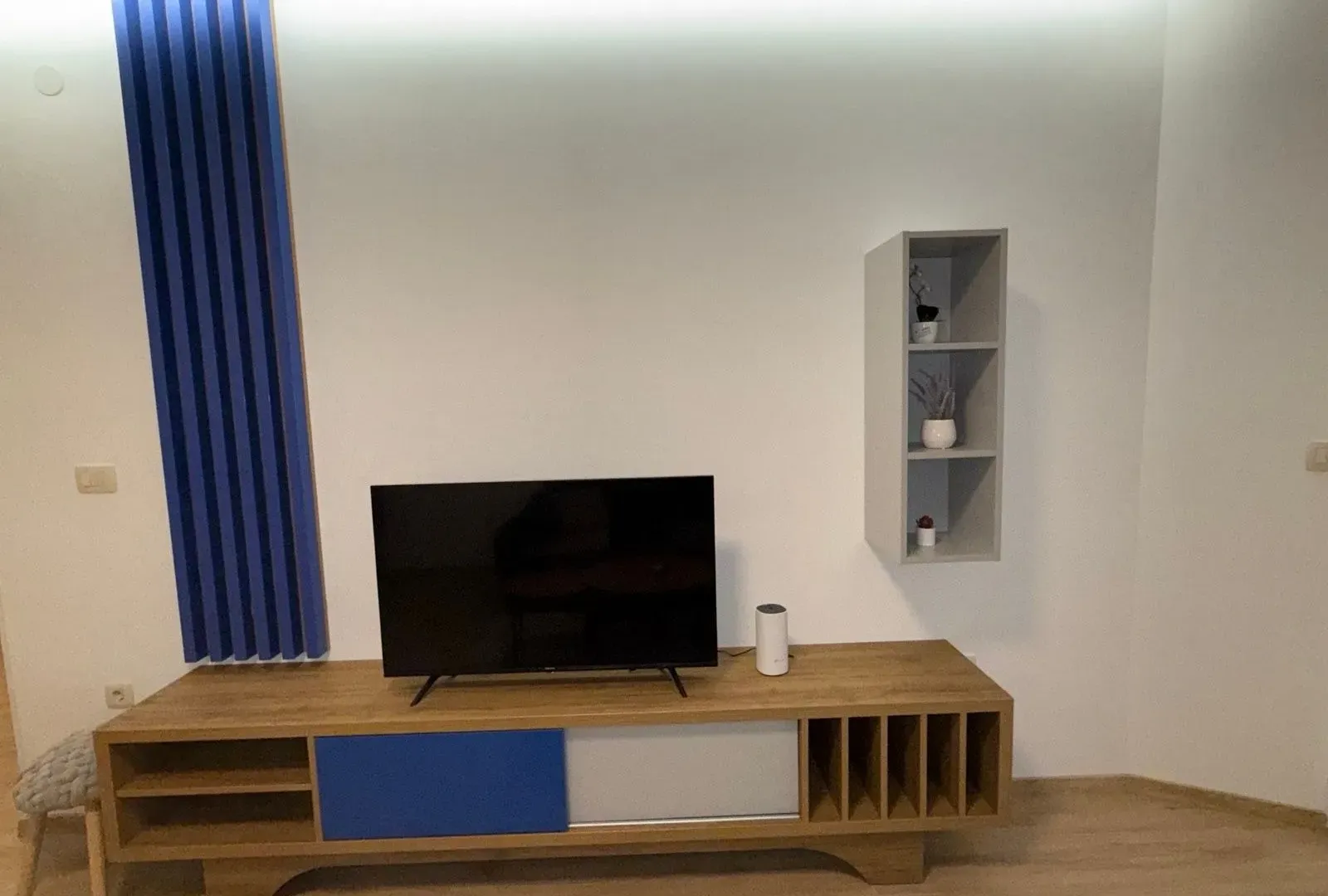 Living room with a TV unit and decorative wall elements.