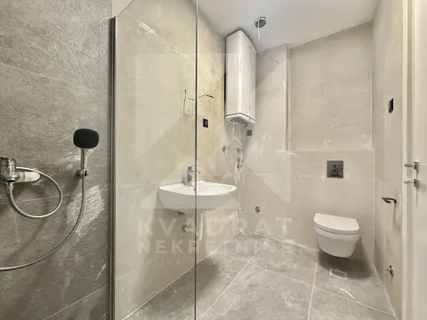 Modern bathroom with a walk-in shower, washbasin, and toilet tiled with ceramic tiles. - image 8