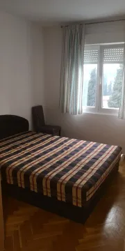 Jednostavno namještena spavaća soba sa bračnim krevetom i prozorom. - image 9