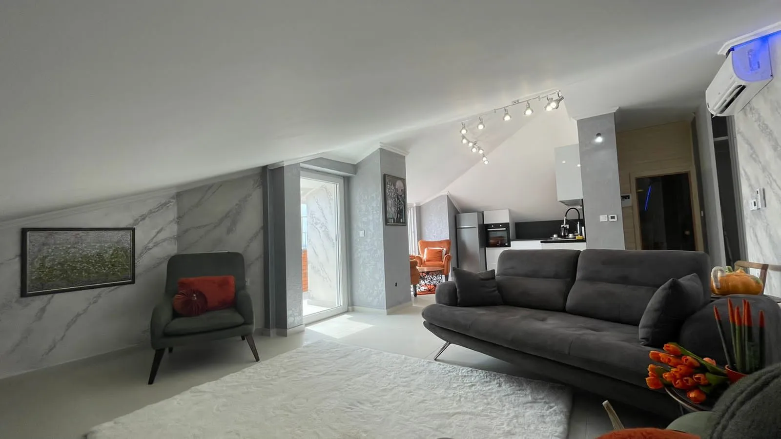 Spacious living room with a sofa set and a view of the kitchen.