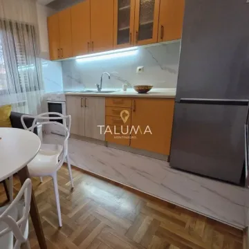 Kitchen equipped with orange cabinetry and a dining table with white chairs. - image 2