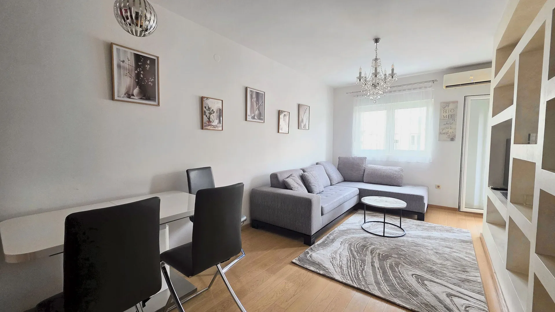 Living room with sofa, dining table, and built-in shelving.