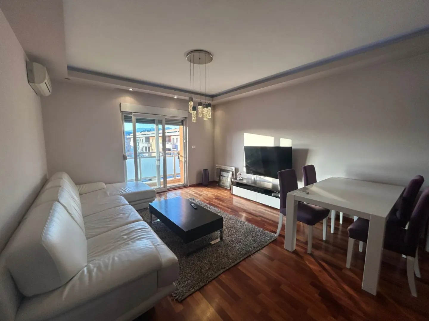 Spacious living room with a sofa, dining table, and access to the terrace.