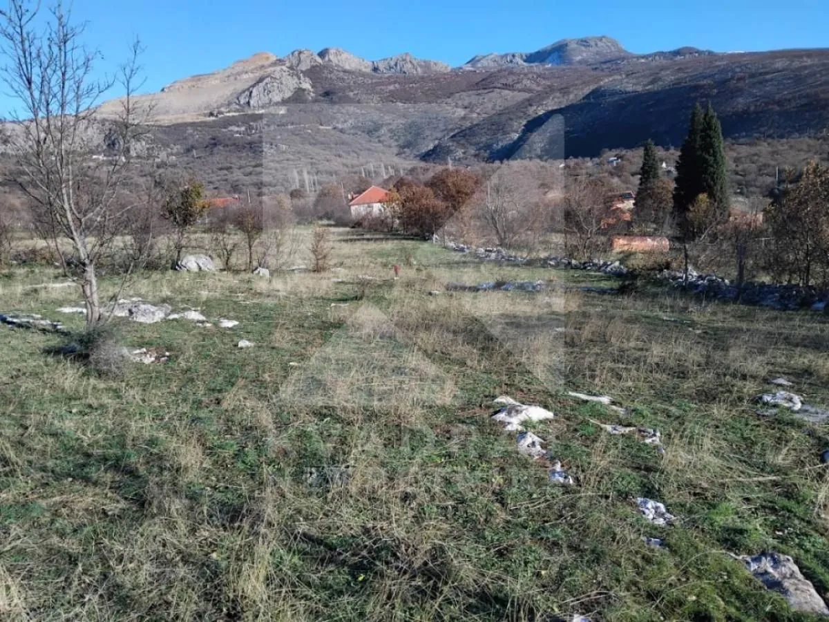 Pogled na zemljište i okolni pejzaž sa planinama u pozadini.