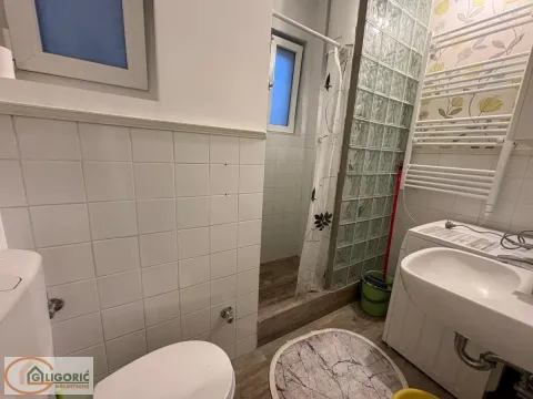 Smaller bathroom with a shower cabin, washbasin, and toilet. - image 9