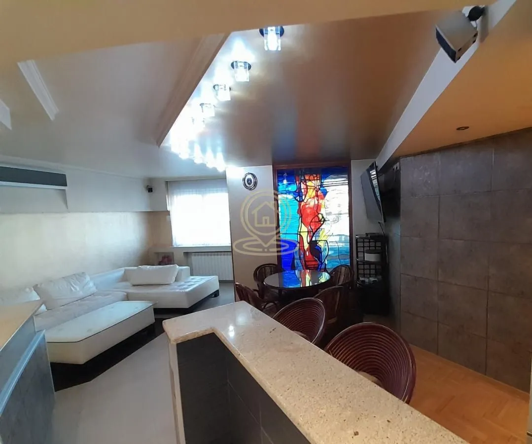 Spacious living room with seating area, dining space and a bar counter.