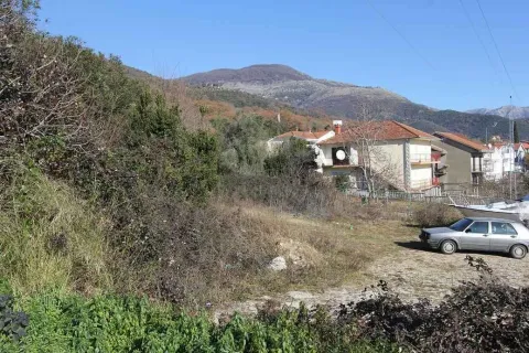 Pogled na građevinsko zemljište sa kućama i brdima u pozadini. - image 5