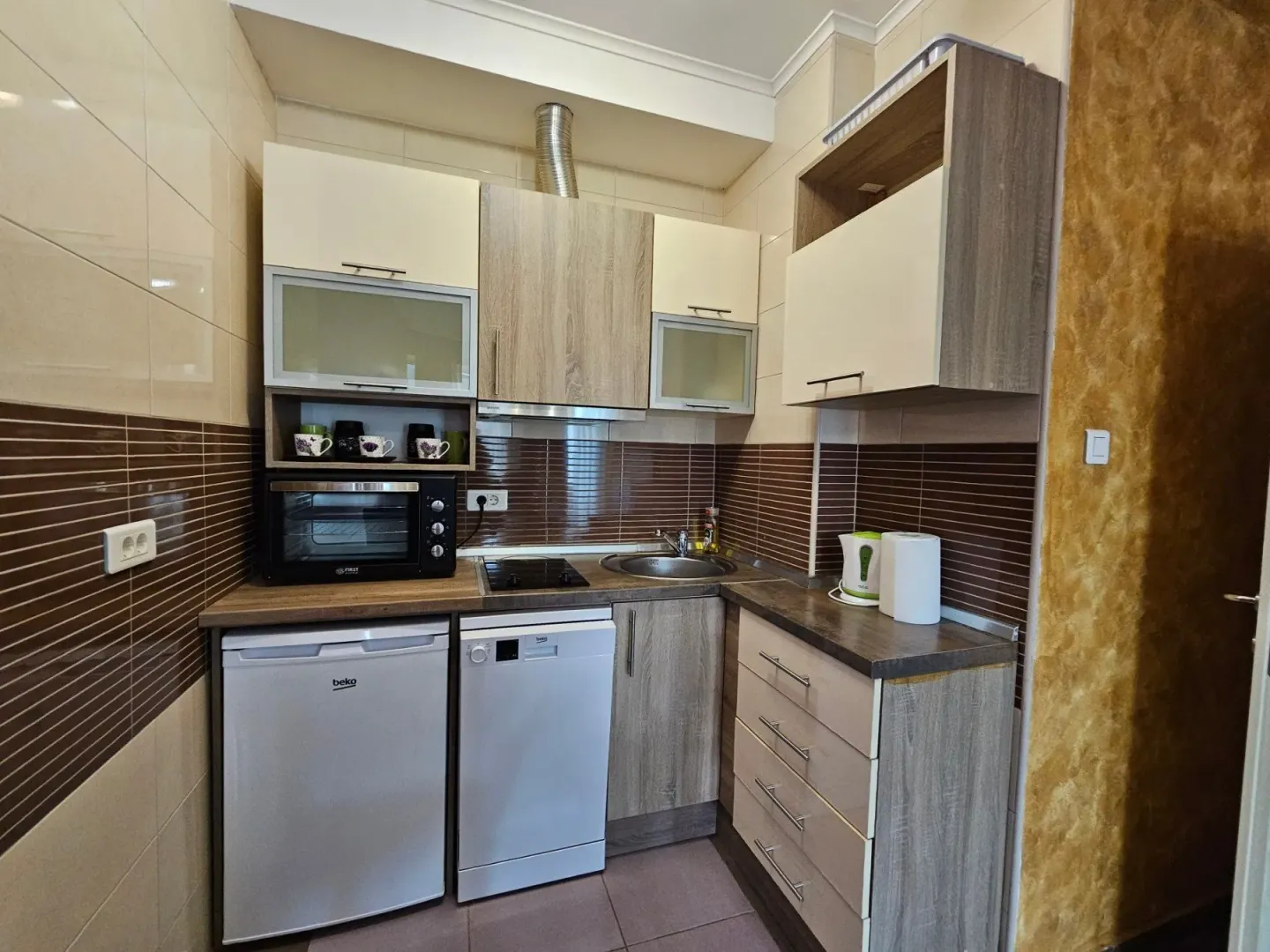 Small equipped kitchen with lower and upper cabinets.