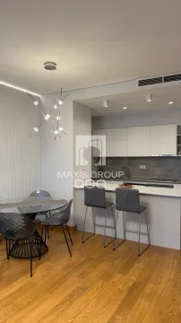 Modern kitchen with a breakfast bar and dining table. - image 3