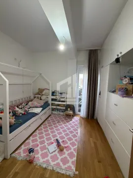 Dječja spavaća soba sa krevetom, bijelim ormarima i roze tepihom. - image 7