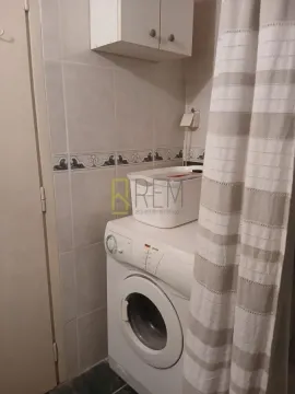 Small bathroom with a washing machine and shower curtain. - image 12