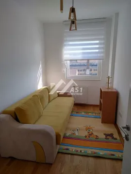 Manja dnevna soba sa žutim kaučem, tepihom sa dečijim motivima i prozorom. - image 8