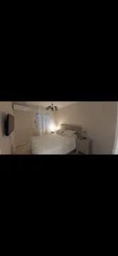 Namještena spavaća soba sa bračnim krevetom, noćnim stočićima i televizorom na zidu. - image 7