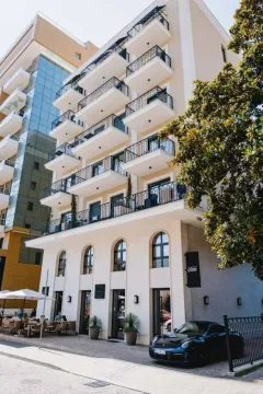 Exterior of a multi-story residential building with balconies and a car in the yard. - image 5