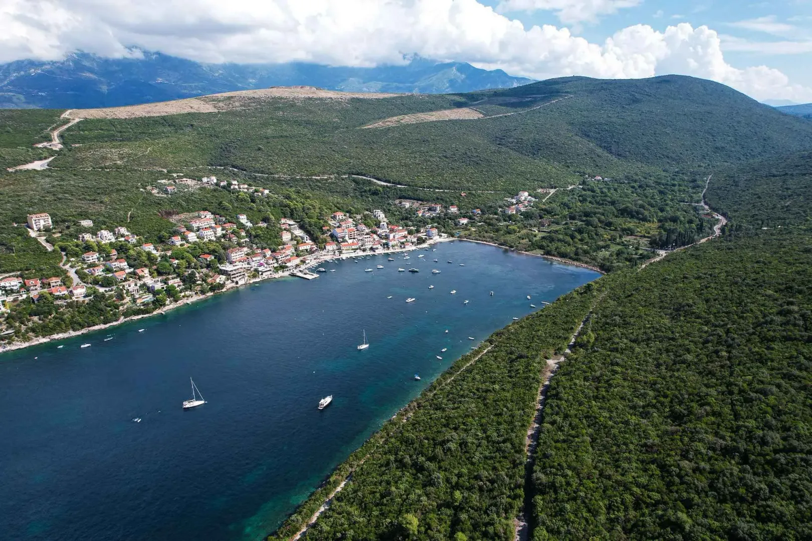 Pogled iz vazduha na zaliv, naselje i okolne planine.