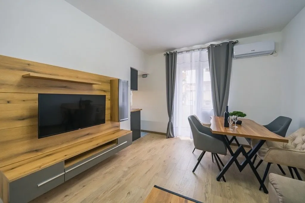 Living room with a wooden TV wall panel and a dining table.