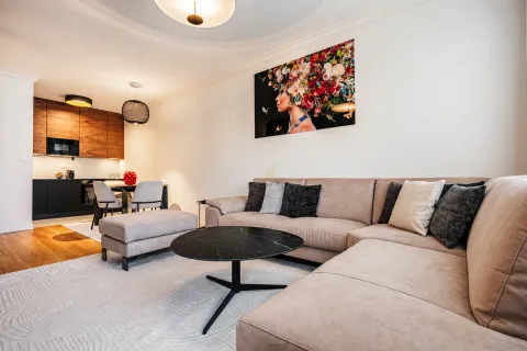 Living room with a sofa and a view towards the kitchen and dining area. - image 4