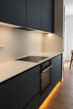 Modern kitchen with dark cabinets, built-in oven, and cooktop. - image 3