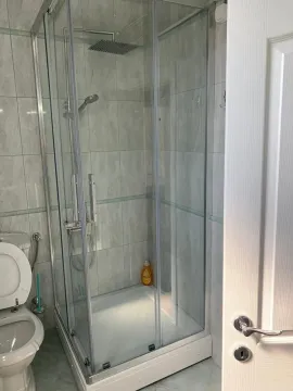 Bright bathroom with a glass shower cabin. - image 21