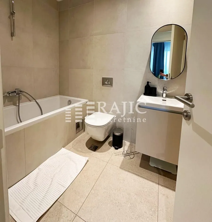Modernly equipped bathroom with a bathtub and a washbasin.