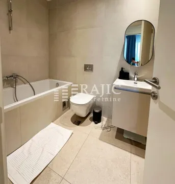 Modernly equipped bathroom with a bathtub and a washbasin. - image 3