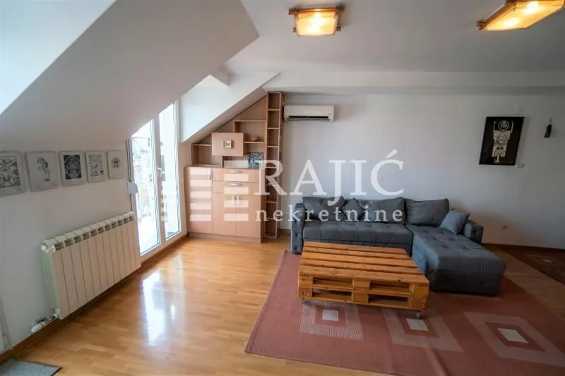 Attic living room with a sofa and wooden coffee table.