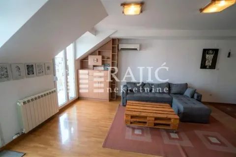 Attic living room with a sofa and wooden coffee table. - image 6