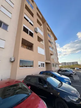 Pogled na spoljašnost stambene zgrade i parking ispred. - image 18