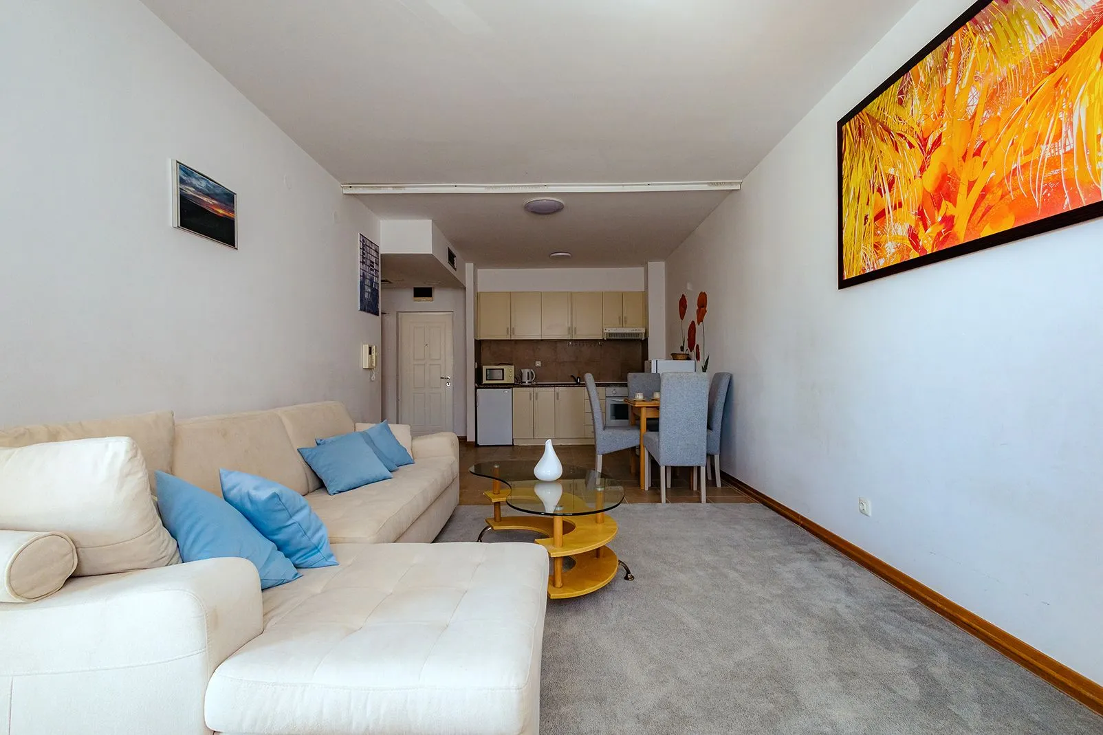 Living room with sofa and view of the dining area and kitchen.