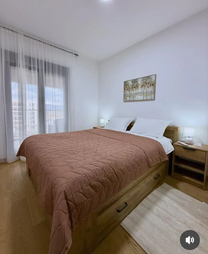 Modern bedroom with a double bed, nightstands, and access to the terrace.