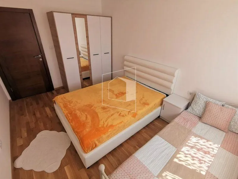 Furnished bedroom with a double bed, wardrobe, and wooden floor.