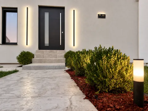 Main entrance to the house with an illuminated walkway and landscaped yard. - image 4