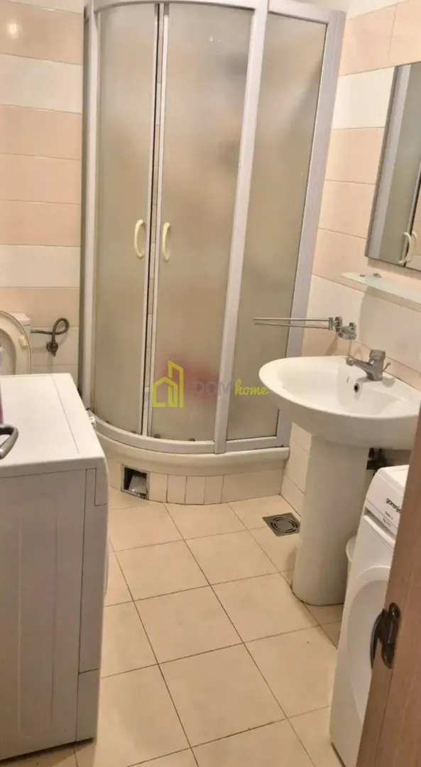 Kupatilo sa tuš kabinom, umivaonikom i veš mašinom.