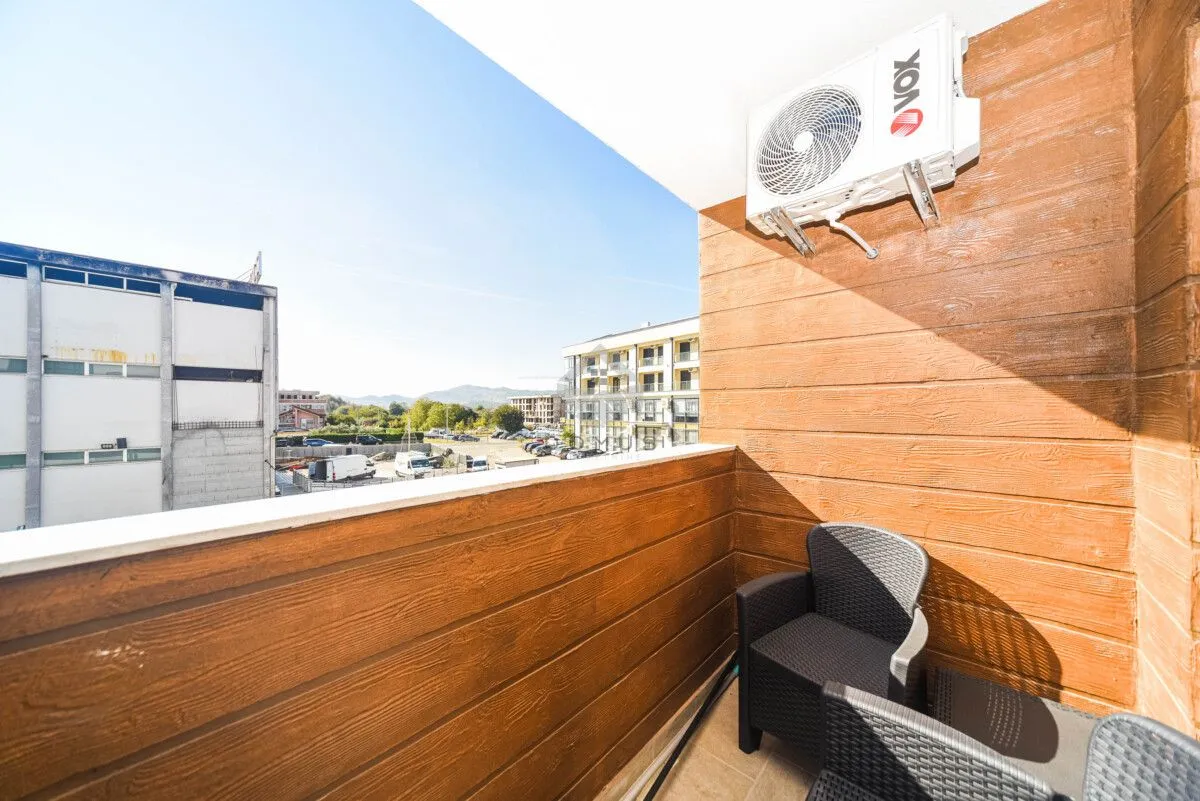 Namtješten balkon sa garniturom za sjedenje i klima uređajem.