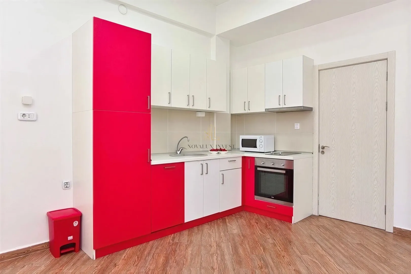 Small kitchen with white and red cabinets and a built-in oven.