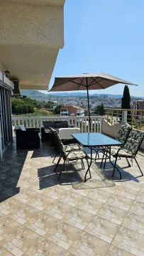 Spacious terrace with seating furniture and a city view. - image 2
