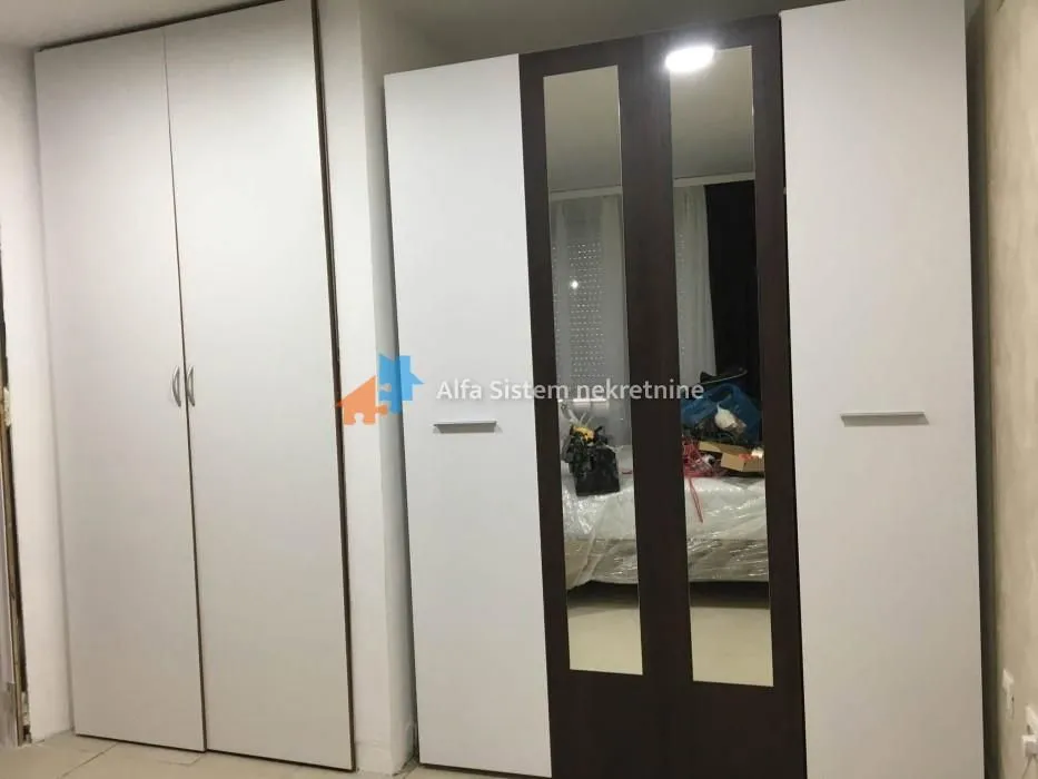 Bedroom with large fitted wardrobes and a mirror.
