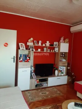 Dnevna soba sa crvenim zidom i nameštajem sa televizorom. - image 3