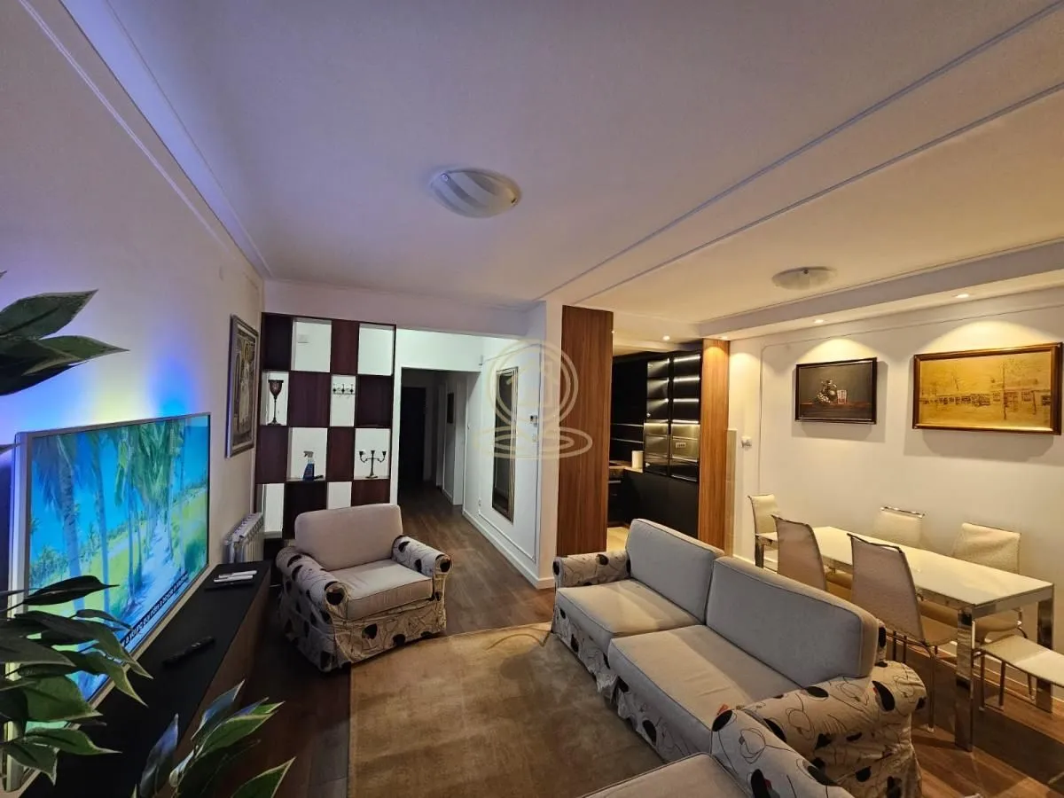 Spacious living room with seating furniture, television, and dining area.