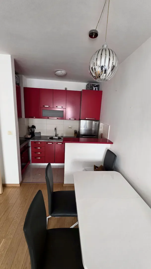 Kitchen with red cabinetry and a dining table with chairs.