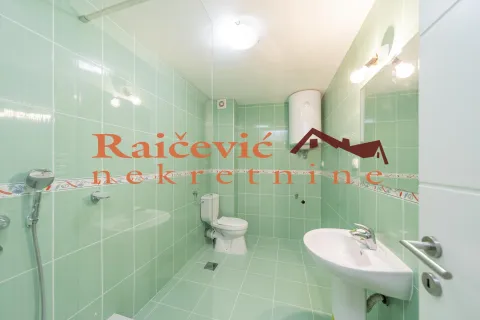Kupatilo obloženo zelenim pločicama sa tuš kabinom, umivaonikom i WC šoljom. - image 12