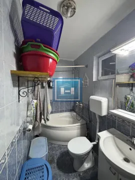 Kupatilo obloženo pločicama sa ugaonom kadom, umivaonikom i toaletom. - image 10