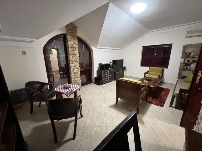 A living room with comfortable furniture under a sloped ceiling.