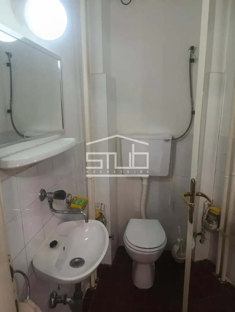 Small bathroom with a sink, mirror, and toilet.