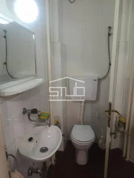 Small bathroom with a sink, mirror, and toilet. - image 2
