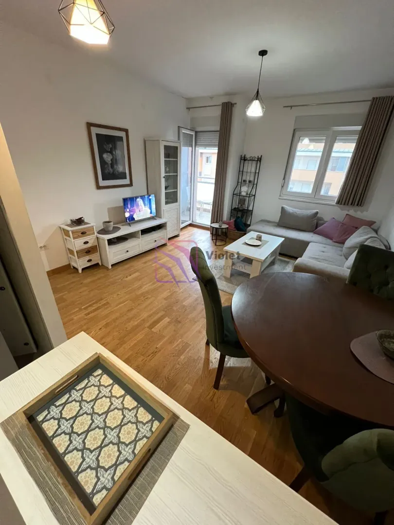 Dnevna soba sa trpezarijom, garniturom i TV-om.